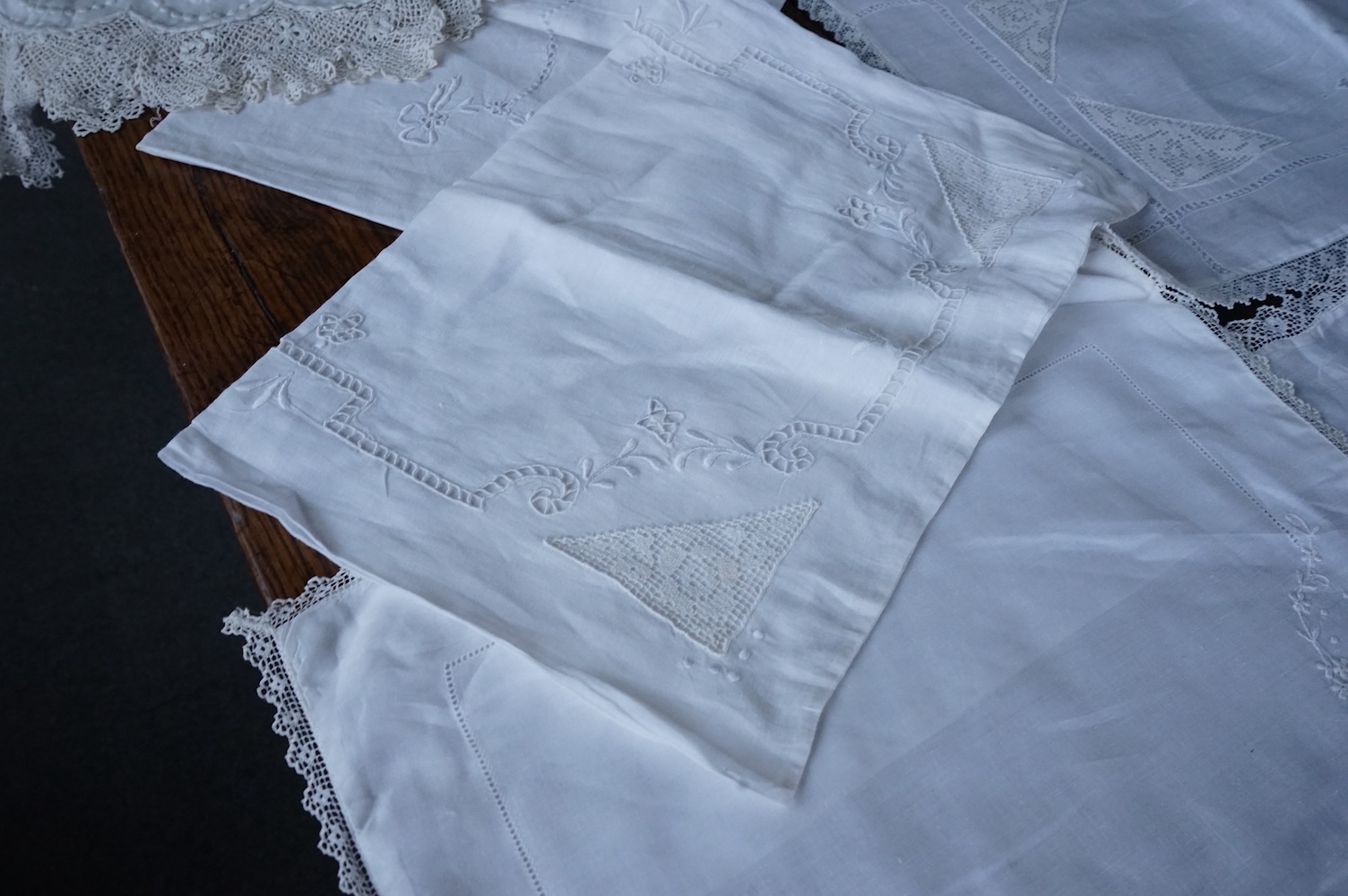 Ten fine linen baby’s pillowcases, eight inset and edged with fillet lace, together with a large fine linen red bordered 19th century ladies kerchief, and three other items. (14) Kerchief 54cm x 58cm. Condition - all ite
